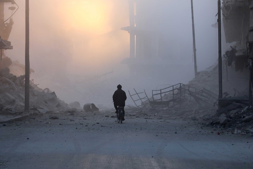 A man rides a bicycle in Eastern Aleppo, November 26, 2016.