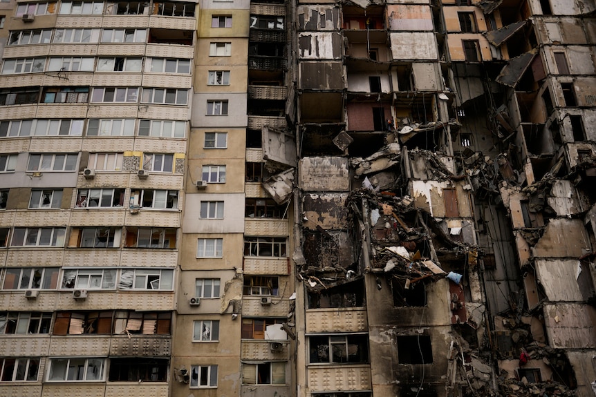 Escombros colgando de un edificio de apartamentos parcialmente destruido en el distrito Saltivka de Járkov.