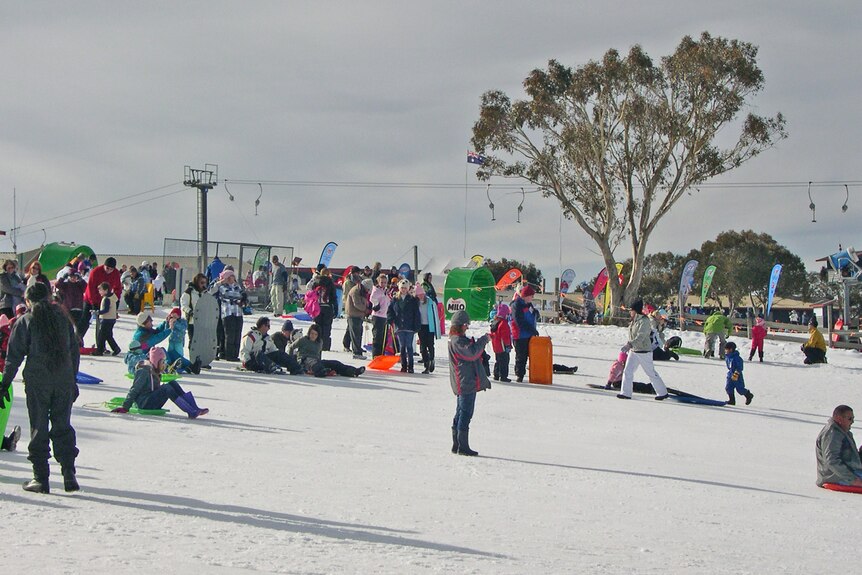 Beaucoup de gens se tiennent dans une station de ski.