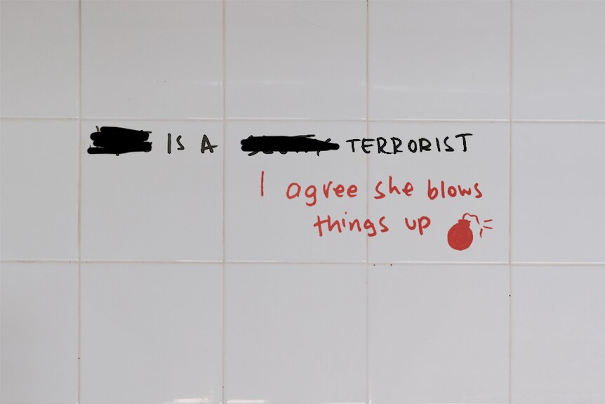 Graffiti written on white tiles in bathroom