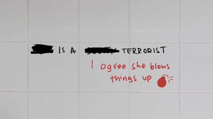 Graffiti written on white tiles in bathroom