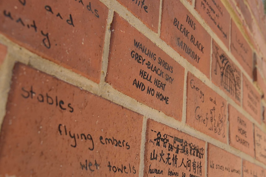 The bricks are inscribed with messages of grief and gratitude.