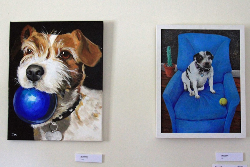 Two paintings of dogs on a wall