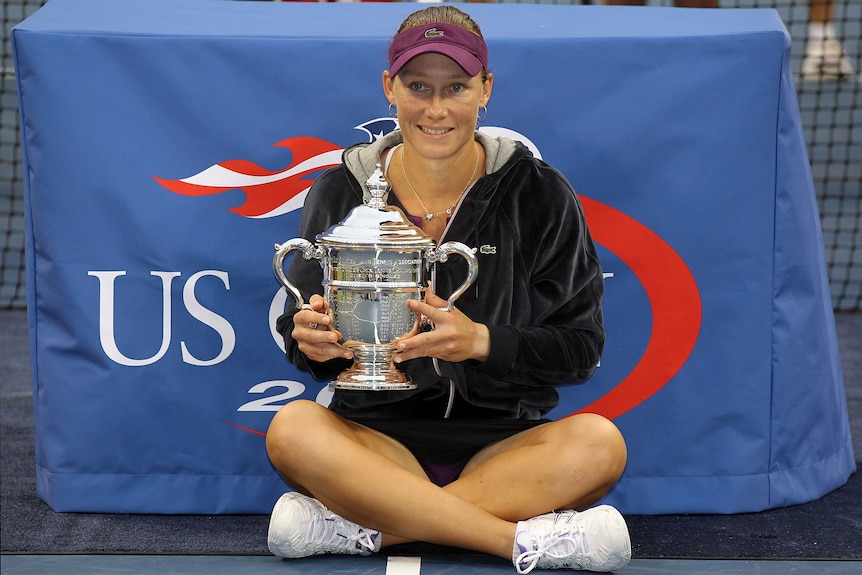 Australia's Sam Stosur smiles and sits cross-legged as she holds the US Open trophy after winning the title in women's singles.
