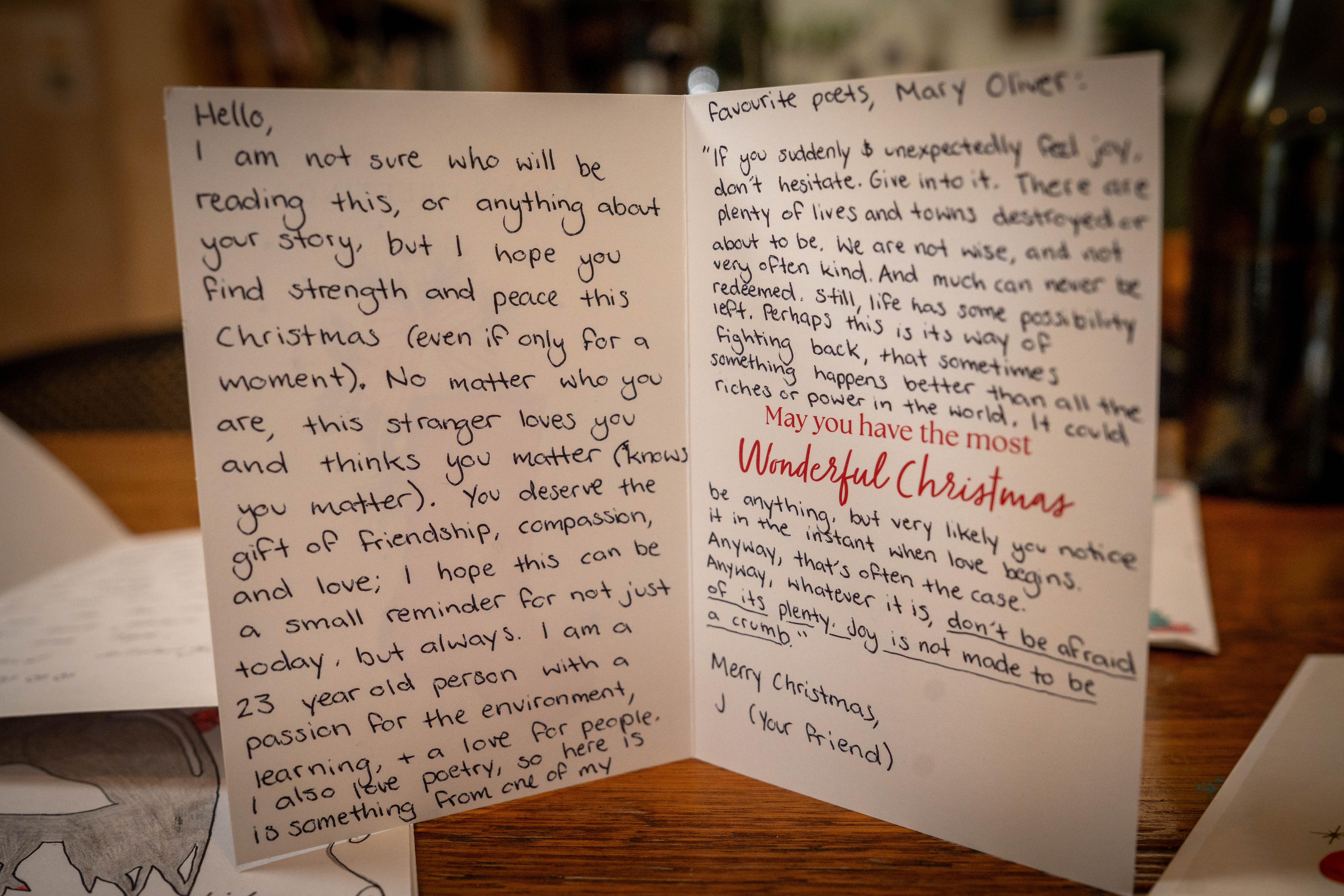 Un largo mensaje escrito con bolígrafo en ambos lados de una tarjeta de felicitación navideña.