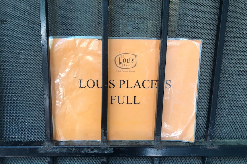 A sign reads' Lou's Place is full' on a door