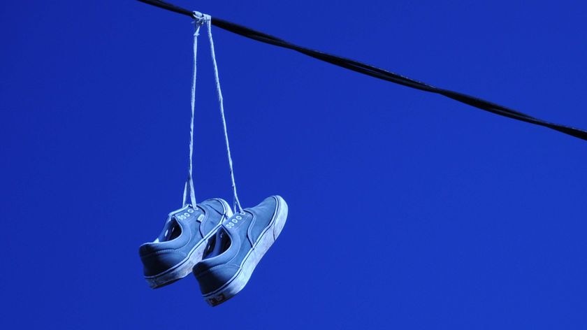 A pair of sneakers hangs from power lines