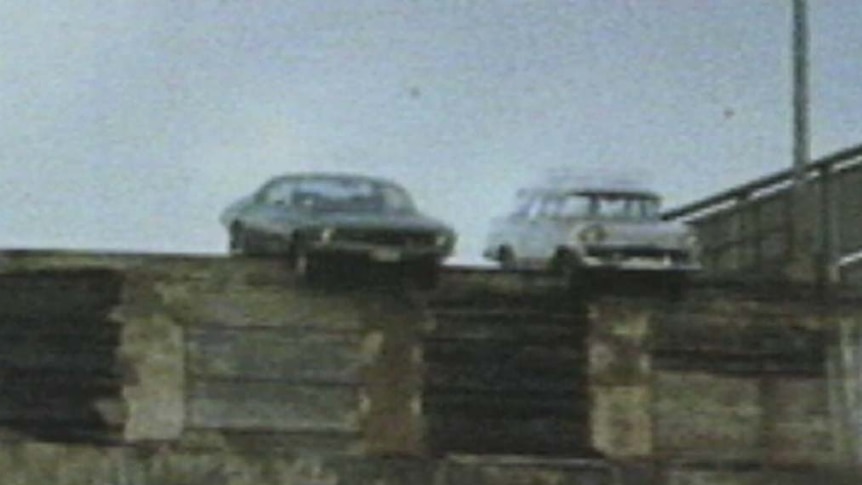 Two cars hang over the edge of Hobart's Tasman Bridge after the 1975 collapse.