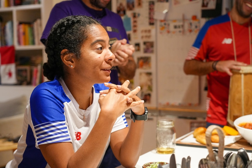 A female Panama fan sits at a table and talks.