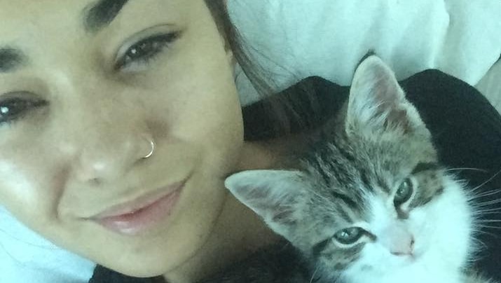 Mia Ayliffe-Chung smiles in a selfie photo taken with a kitten.
