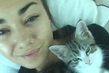 Mia Ayliffe-Chung smiles in a selfie photo taken with a kitten.