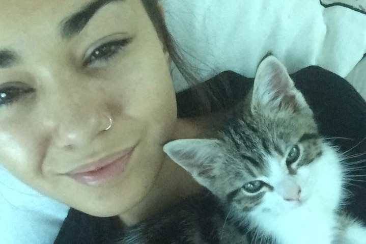 Mia Ayliffe-Chung smiles in a selfie photo taken with a kitten.