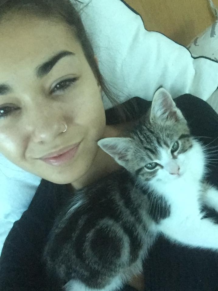 Mia Ayliffe-Chung smiles in a selfie photo taken with a kitten.