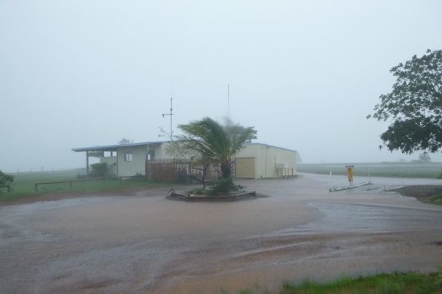 A photo of a house surrounded by flash flooding.