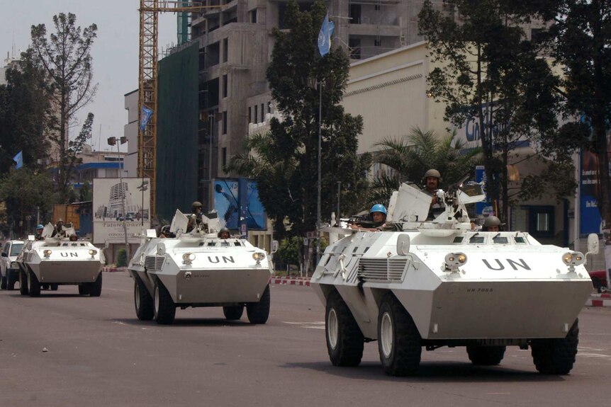 UN troops in armoured vehicles drive through the streets of Kinshasa, Congo.