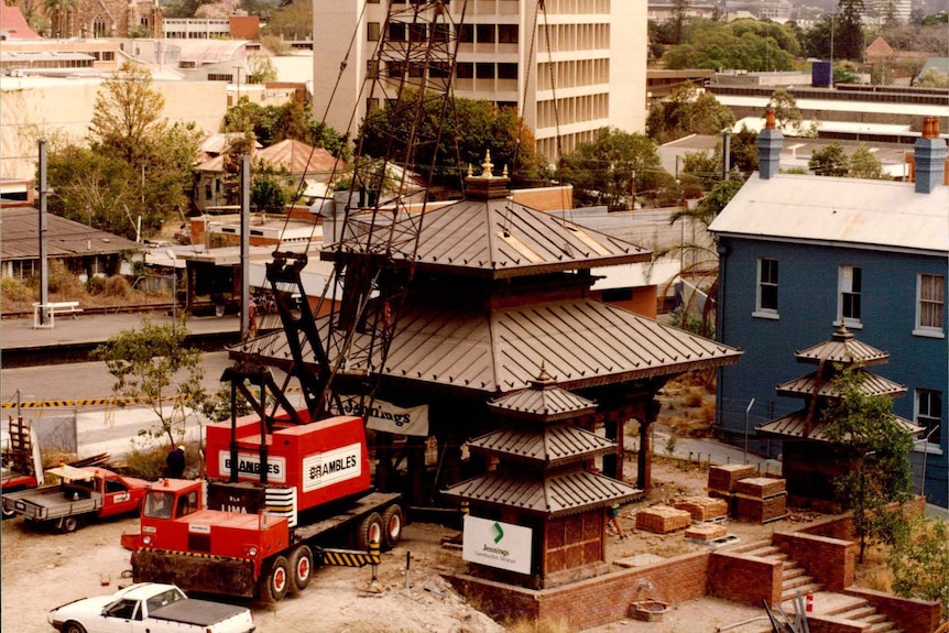 A crane works on the partially finished Nepalese Pagoda.
