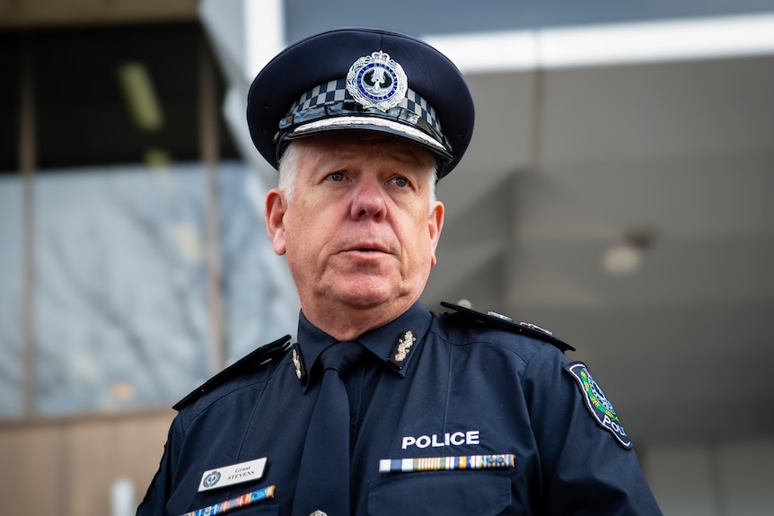 SA Police Commissioner Grant Stevens is standing and wearing a full navy blue police uniform including police hat