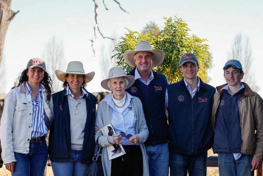 Three men and three women, all smiling and wearing hats.