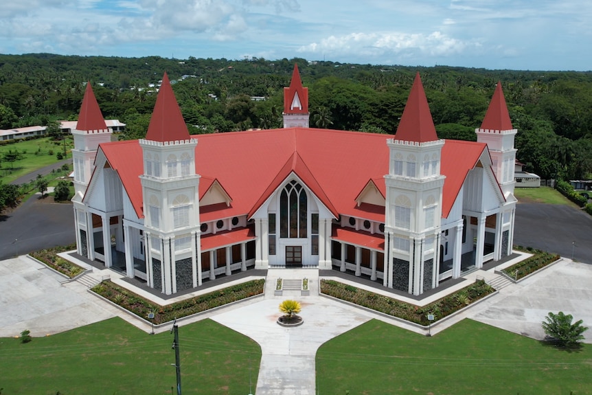 A bird's eye view of St Theresa of the Child Jesus Catholic Church, which has a maroon roof and a Y-shape.