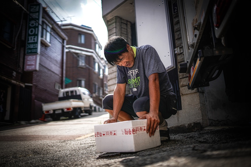 A man lifts a heavy box.