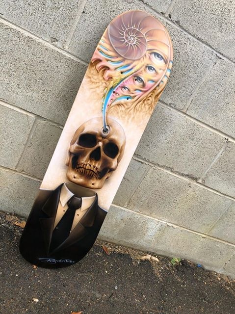 Airbrushed skateboard with skull and colourful eyes at the top.