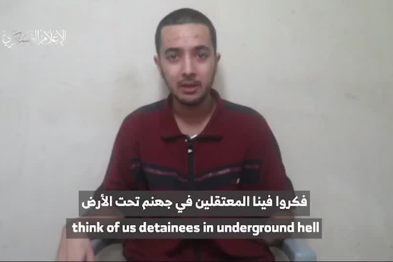 A screenshot of a video of a man with a missing lower arm with arabic text over it.