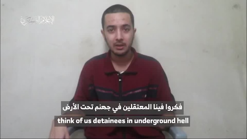 A screenshot of a video of a man with a missing lower arm with arabic text over it.