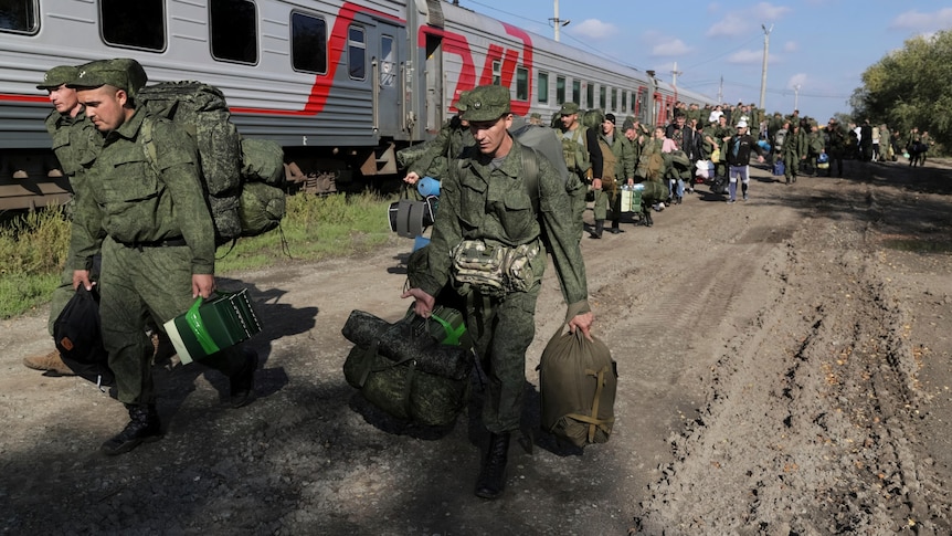 Russian recruits in uniform walk to take a train in Prudboi