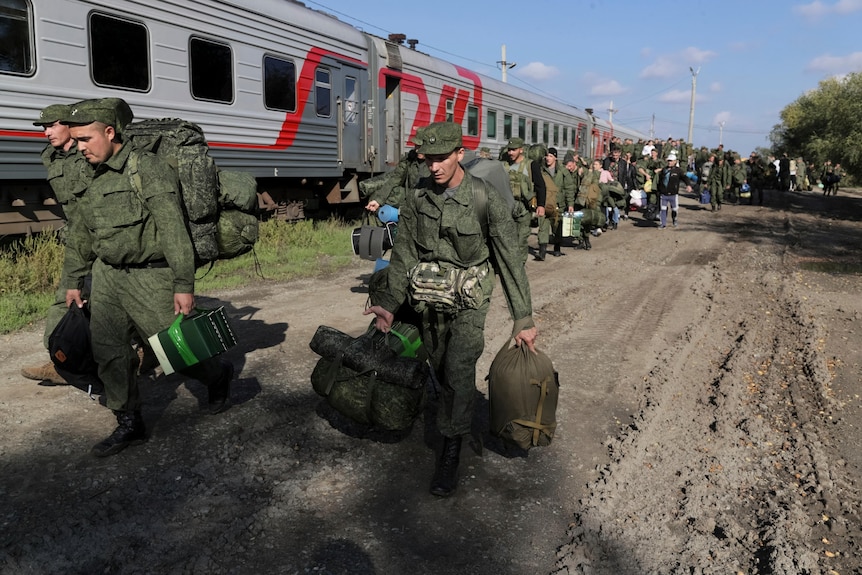 Russian recruits in uniform walk to take a train in Prudboi