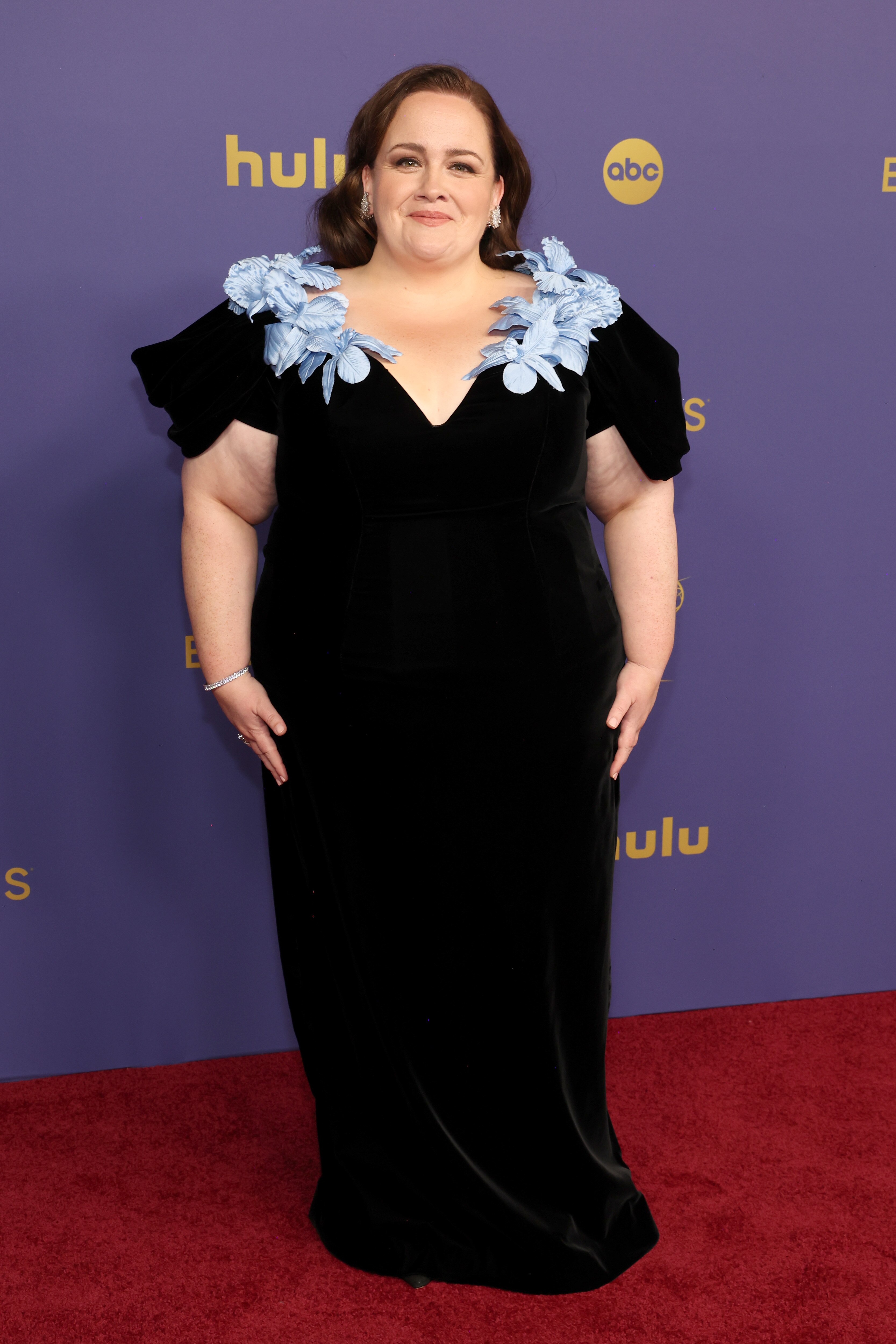 Jessica Gunning wearing a velvety black long gown with a deep v neckline lined with baby blue flowers