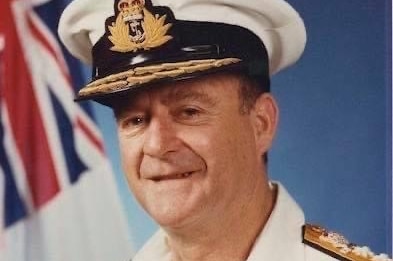 Portrait of a Royal Australian Navy Vice Admiral standing in front of the white ensign