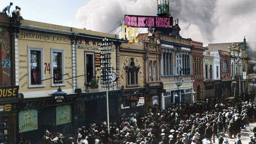 A colourised historical photograph of smoke rising from the John Martin's department store in Adelaide, 1901.