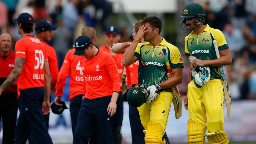 Australia's Marcus Stoinis (C) and Mitchell Starc (R) look dejected after T20 loss to England.