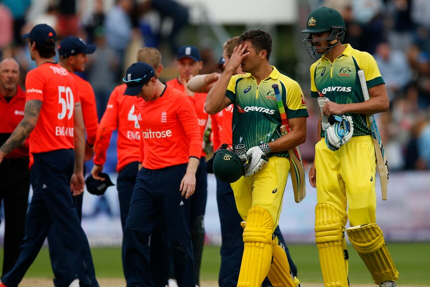 Australia's Marcus Stoinis (C) and Mitchell Starc (R) look dejected after T20 loss to England.