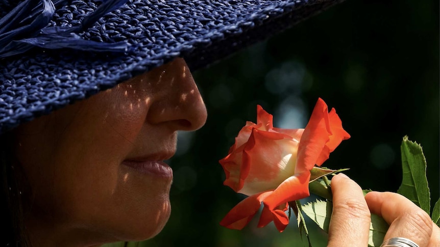 A woman smells a flower