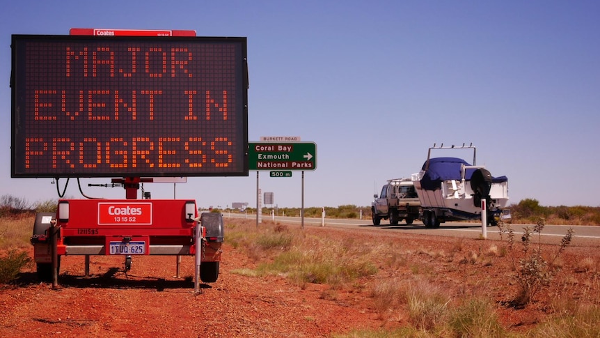 An LED road sign that says "Event in progress" in the outback.