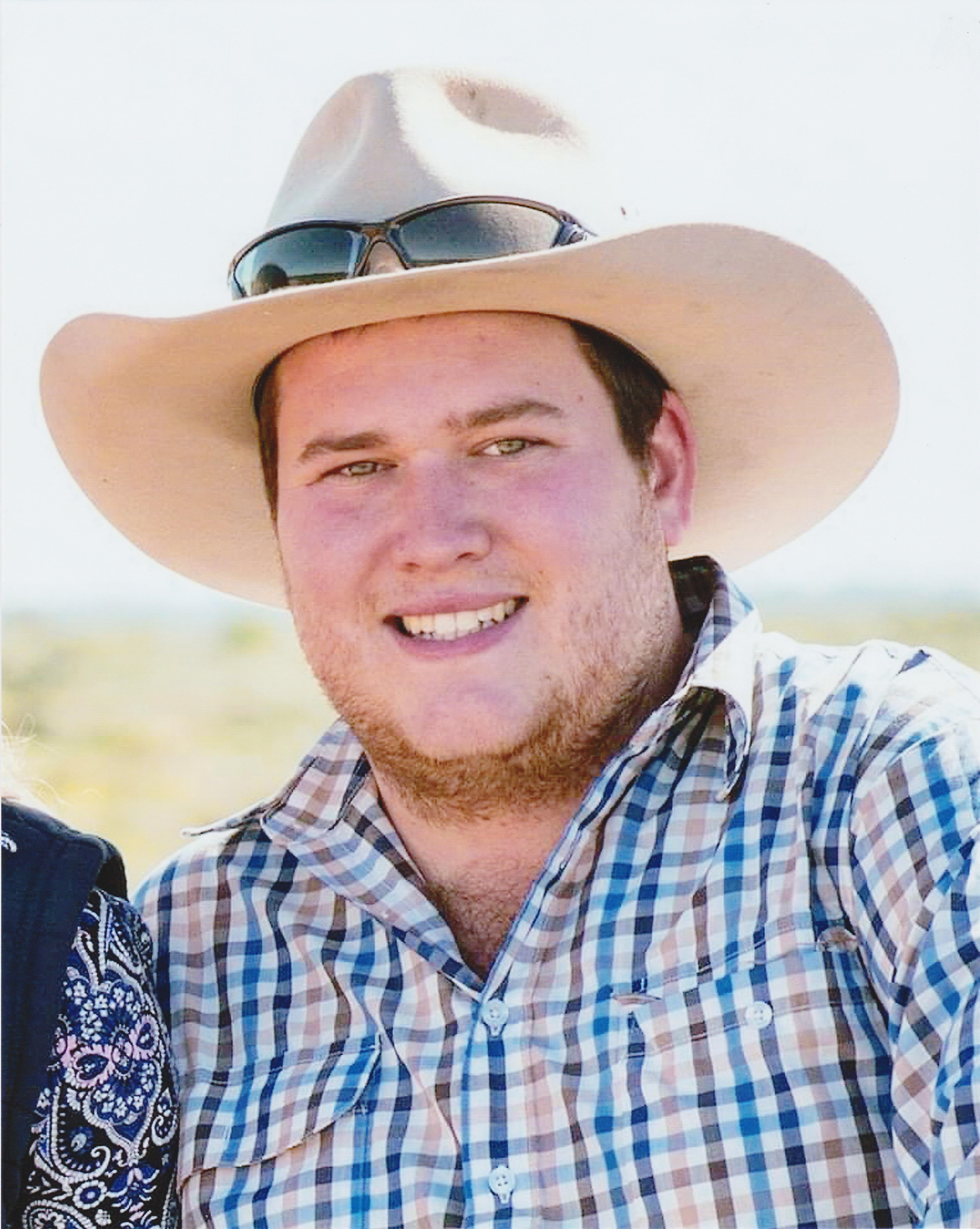 A man in his early 20s smiling at the camera. 