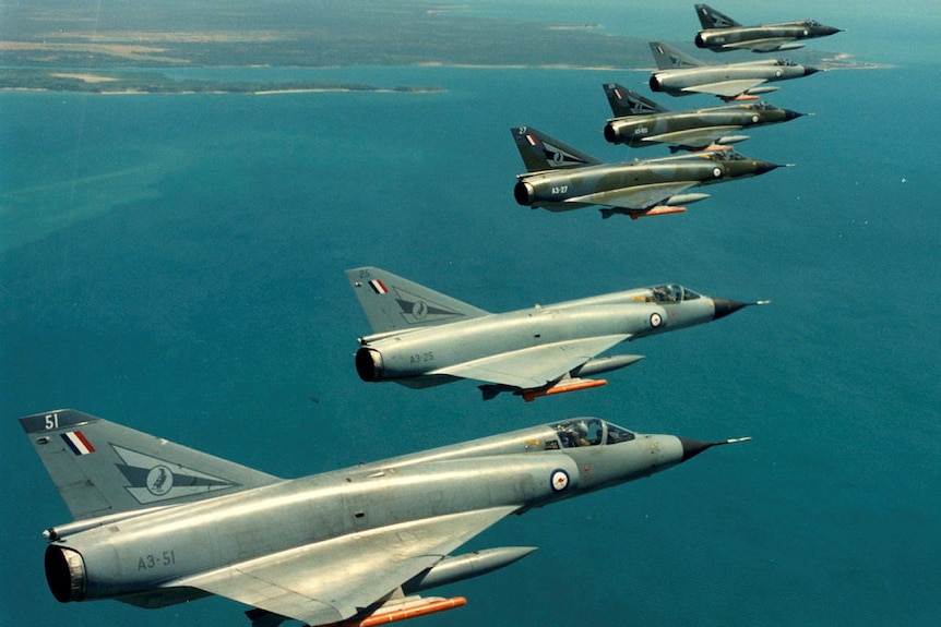 Six Mirage fighter jets in a diagonal line in the sky