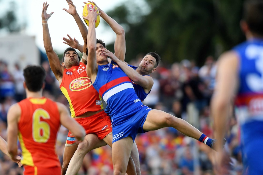 The Bulldogs' Lewis Young (C) marks against the Gold Coast Suns in Cairns on July 22, 2017.