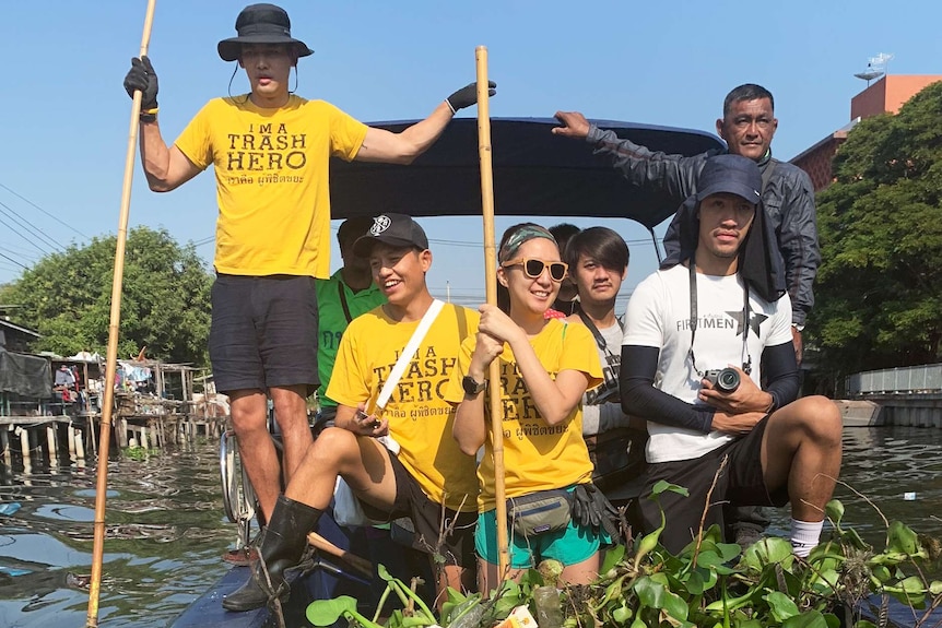 A group of people on a boat in a canal.