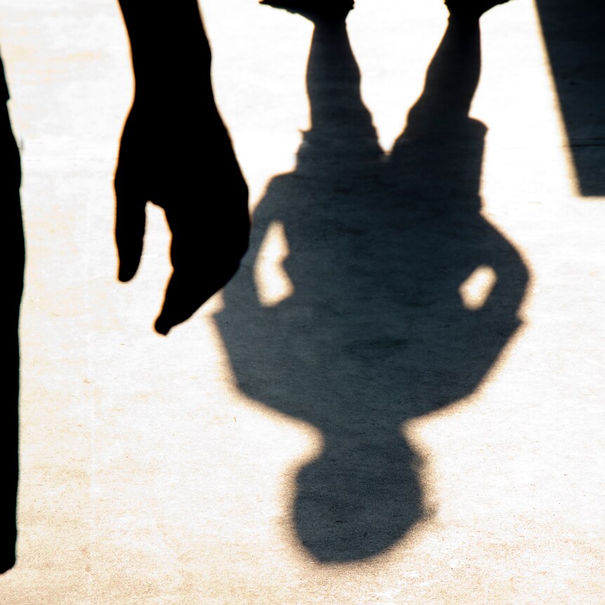 The shadows of two boys are pictured outside, opposing each other 