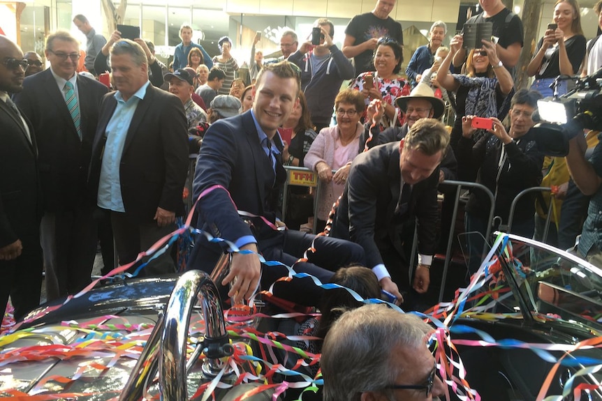 Jeff Horn is covered in streamers sitting on top a vintage car during his ticker tape parade in the Queen Street Mall