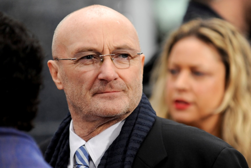 Phil Collins in a suit and tie.