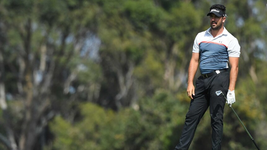Adam Stephens watches a shot from the fairway on the third hole at the Australian Open.