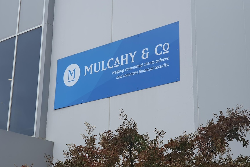 A grey building with a blue sign that reads Mulcahy and Co. 