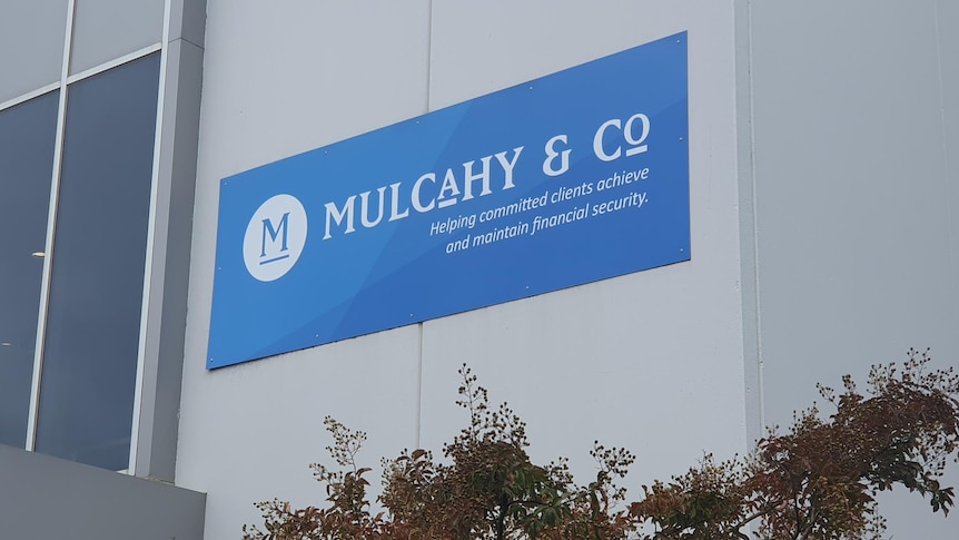 A grey building with a blue sign that reads Mulcahy and Co.