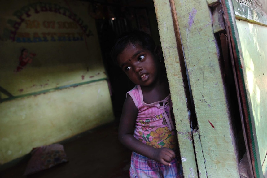 A Tamil girl looks out from her home at an internally displaced persons camp in Jaffna
