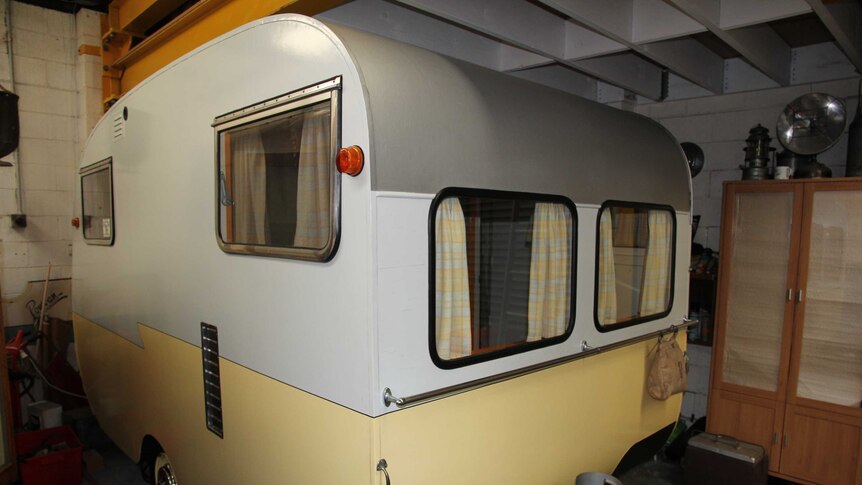 A 1958 plywood caravan stored in a shed.