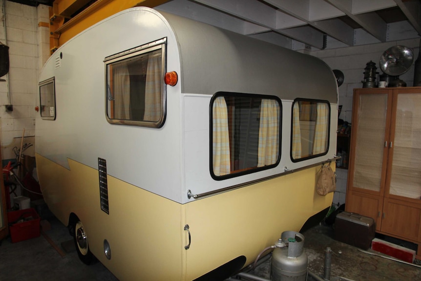 A 1958 plywood caravan stored in a shed.