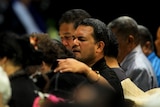 Family members console each other during the Community Prayer Gathering at the Logan Sports Centre in Crestmead